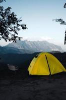 gele tent op de berg en uitzicht op de zonsondergang foto