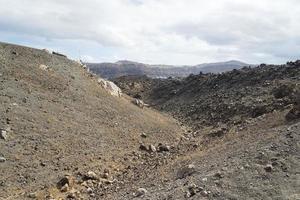 exotische rotsachtige weg naar de krater van de vulkaan. de vulkaan bevindt zich in de beroemde caldera van santorini. foto