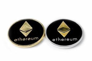 twee echte munten van zilveren en gouden cryptocurrency ethereum, geïsoleerd op een witte achtergrond foto