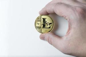 hand houdt een litecoin op een witte achtergrond. foto