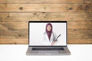vrouwelijke moslimarts die videogesprek voert op sociaal netwerk met patiënt die overleg pleegt over gezondheidsproblemen. foto