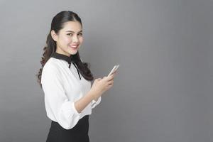 portret van mooie zakenvrouw gebruikt mobiele telefoon in studio