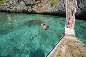 uitzicht vanaf Thaise traditionele longtailboot terwijl toeristen snorkelen en duiken in de oceaan, phi phi-eilanden, thailand foto