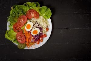 Groentensalade op zwarte houten achtergrond foto