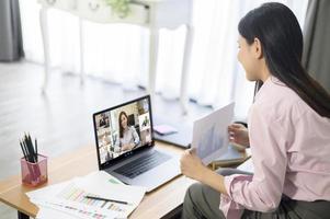 jonge vrouw werkt met haar computerscherm tijdens een zakelijke bijeenkomst via een videoconferentietoepassing. foto