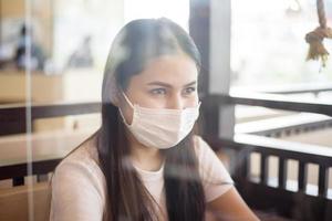vrouw eet in restaurant met protocol voor sociale afstand terwijl de stad wordt afgesloten vanwege een pandemie van het coronavirus