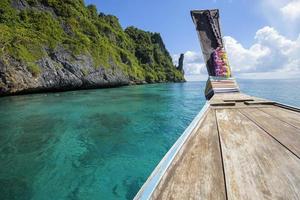 uitzicht op Thaise traditionele longtailboot over heldere zee en lucht in de zonnige dag, phi phi-eilanden, thailand foto