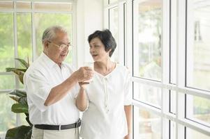 gelukkig bejaarde echtpaar melk drinken en samen tijd doorbrengen thuis, gezondheid en pensioen concept foto
