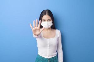portret van een jonge vrouw draagt een gezichtsmasker op een blauwe achtergrond