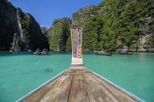 uitzicht op Thaise traditionele longtailboot over heldere zee en lucht in de zonnige dag, phi phi-eilanden, thailand foto