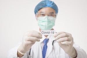 arts houdt covid-19-kaart op witte achtergrond foto