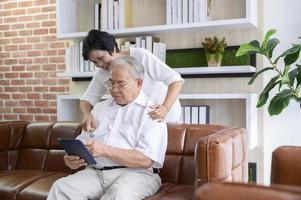 een gelukkig senior Aziatisch stel gebruikt tablet en praat met familie op webcam thuis, pensioenconcept. foto