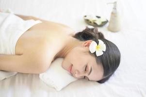 een mooie vrouw ontspant en heeft massage in het kuuroord, massage- en schoonheidsbehandelingsconcept. foto