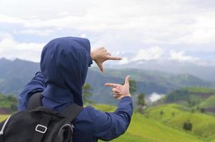 reizende man genieten en ontspannen over prachtige groene bergen in het regenseizoen, tropisch klimaat. foto