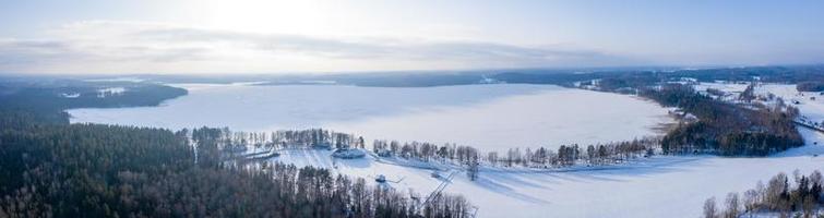 luchtfoto van winterlandschap, panorama van het bevroren meer in het midden van een bos. winter Wonderland. foto