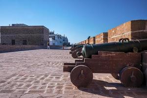 oud kanon gericht door spleet in stenen muur op historisch fort foto