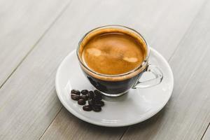 verse warme kop gezette espressokoffie geserveerd op een schotel in vintage houten tafel foto