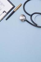 stethoscoop, tablet met papieren en pen op een blauwe achtergrond. vrije ruimte voor medische teksten. medisch concept foto