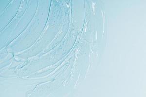 abstracte cosmetische achtergrond van dikke transparante gel of antiseptisch, hyaluron op blauwe achtergrond foto