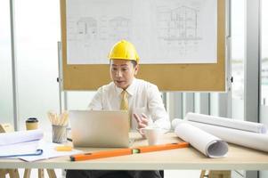 een mannelijke ingenieur die een laptop gebruikt en een videogesprek voert met een klant of zakenpartner, foto