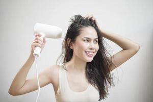 een vrouw droogt haar haar na het douchen foto