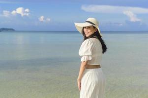 een gelukkige mooie vrouw in een witte jurk die geniet en ontspant op het strand, zomer en vakantie concept