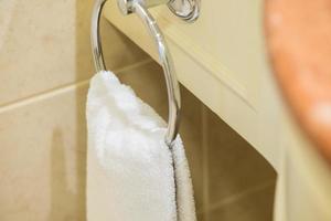 witte badstof handdoek hangend aan een hanger in de hotelbadkamer foto