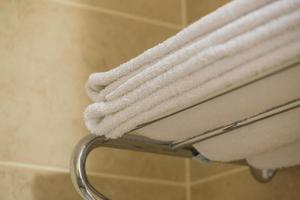 witte badstof handdoek op de plank in de hotelbadkamer foto