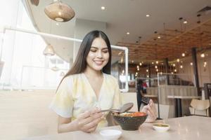 vrouw eet in restaurant met protocol voor sociale afstand terwijl de stad wordt afgesloten vanwege een pandemie van het coronavirus foto