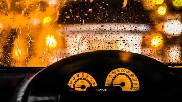 interieur van de auto als het regent. onscherpe vervaging van licht op de weg in een regenachtige dag