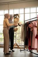beide moslimvrouwen runnen een klein bedrijfje in hun eigen huis. is het ontwerpen en afstemmen van kleding. foto