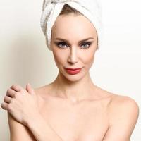 mooie blonde vrouw met witte handdoek op haar hoofd. foto