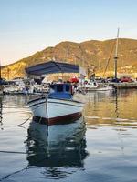 een verankerde boot in de zee bij de jachthaven met mooie weerspiegeling in het water bij skopelos, griekenland. foto