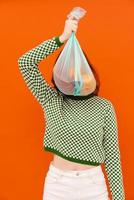 jonge vrouw die geruite trui draagt met plastic vuilniszak foto