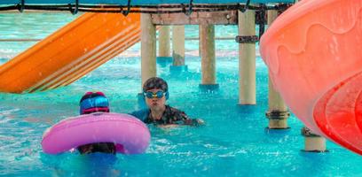 kinderen dartelen in het waterpark. het is een zonnige, perfecte dag om nat te worden en hard te spelen foto