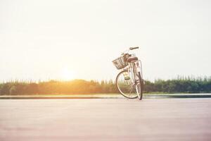 vintage afgezwakt van fiets met mand op lege pier, zomerdag. foto