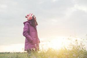 jonge vrouw is blij met de bloemen terwijl de zonsondergang en de winter eraan komen. vakantie genieten. foto