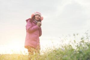 jonge vrouw is blij met de bloemen terwijl de zonsondergang en de winter eraan komen. vakantie genieten. foto