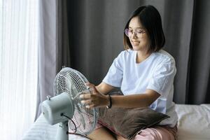 vrouw die een wit overhemd en een handvat aan de ventilator draagt. foto