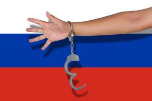 handboeien met hand op de vlag van rusland foto