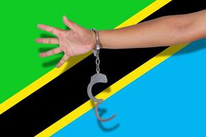 handboeien met hand op de vlag van Tanzania foto