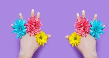 vrouw hand en gele, blauwe, roze bloemen geïsoleerd op de achtergrond. zomer en lente concept. modeontwerp en manicure. bovenaanzicht en kopieer ruimte. bespot moederdag. banier foto