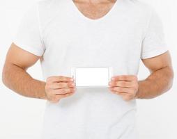 sterke man in t-shirt houdt leeg scherm telefoon geïsoleerd op een witte achtergrond, fitness apps. bovenaanzicht, mock up, kopieer ruimte, sjabloon, blanco foto