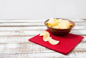 Aardappelchips, rode servet op houten table.tablecloth vakantieconcept foto