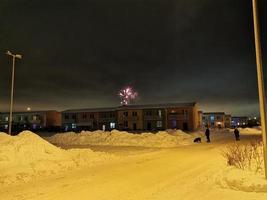 nieuwjaarsvuurwerk in het huisjesdorp op een winternacht foto