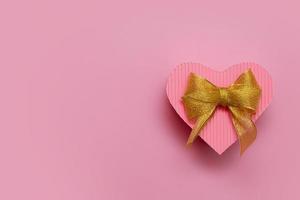 hartvormige doos roze kleur met gouden strik - cadeaus voor Valentijnsdag, verjaardag, moederdag met kopieerruimte foto