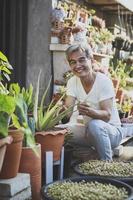 Aziatische senior man die lacht met geluk gezicht zittend in huis tuin foto