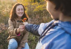 een kind geeft een bloem aan zijn moeder foto