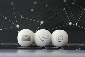 pictogram op houten bal van website en internet neem contact met ons op pagina concept op computer laptop toetsenbord en sociale media diagram foto