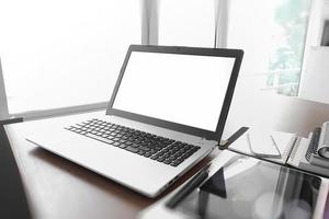 kantoor werkplek met laptop en smartphone op houten tafel foto
